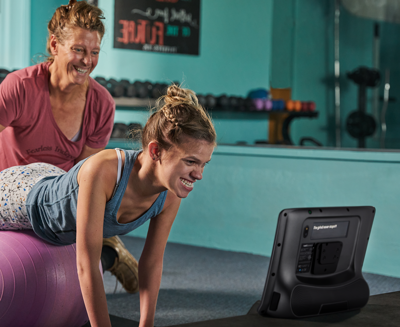 Woman using her Tobii Dynavox TD I-Series assistive technology device at the gym