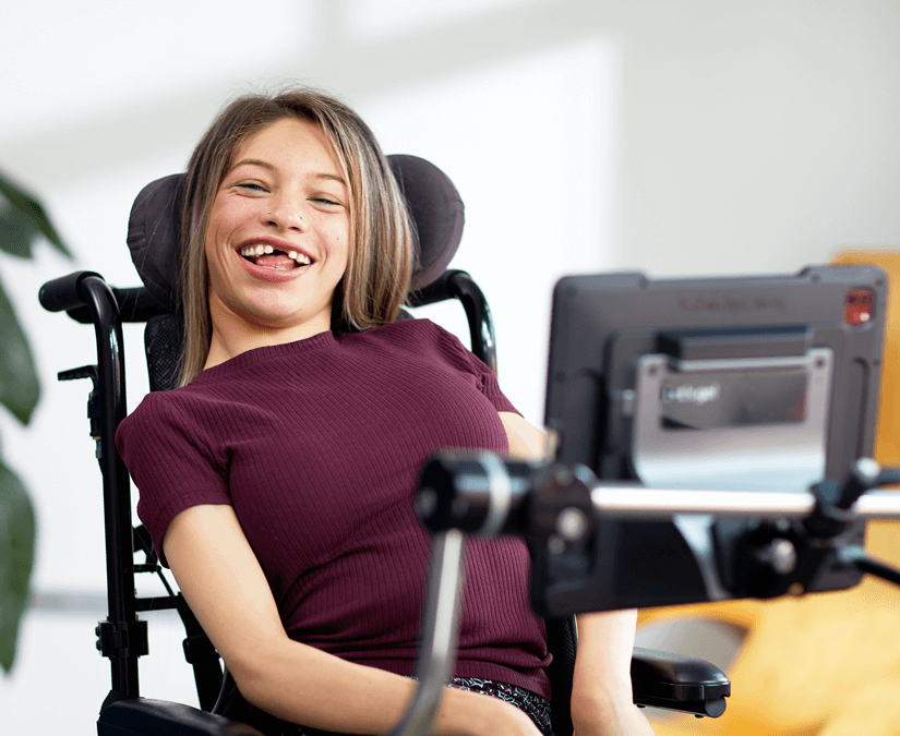 Young girl using TD Pilot speech generating device to communicate